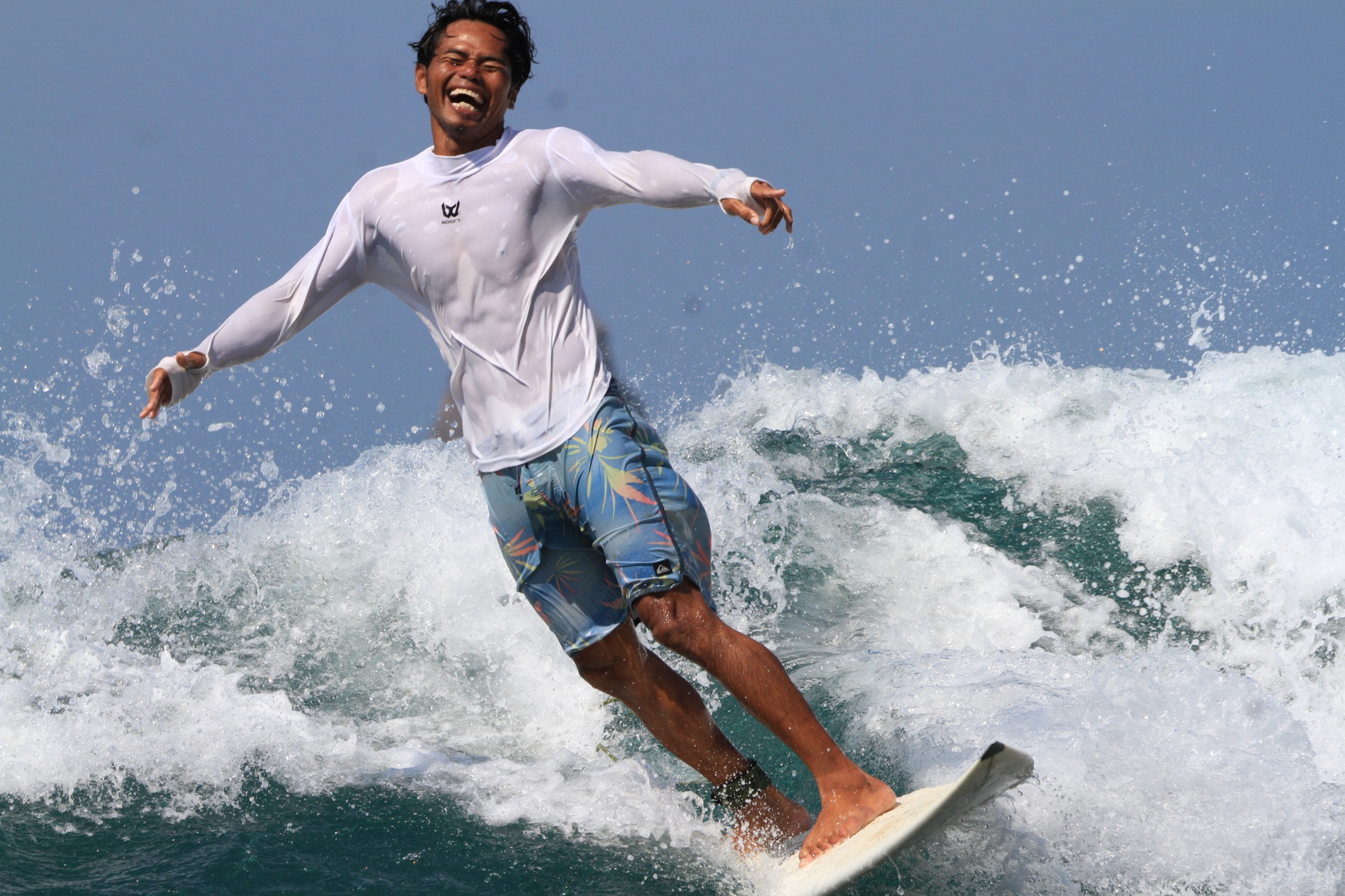 Dedy surfing and smiling in the waves