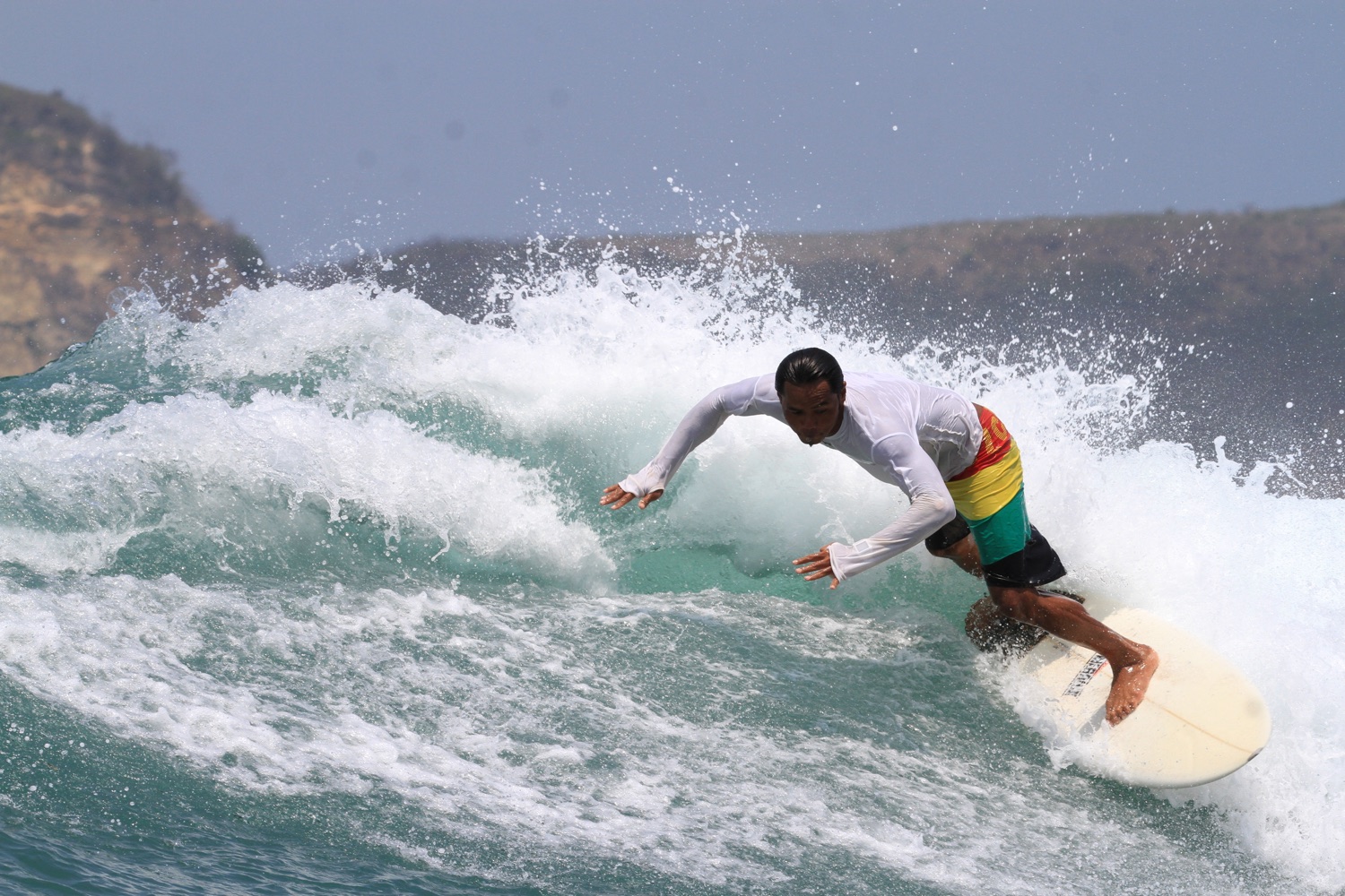 Dedy surfing a breaking wave