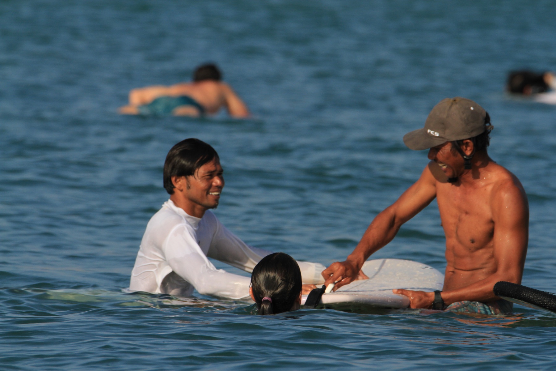 Dedy coaching a surfer in the water